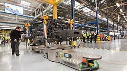 Driverless transport vehicles (AGVs) have replaced a transfer belt and are able to carry tractors weighing up to 20 tonnes with flexibly timed sequences. -